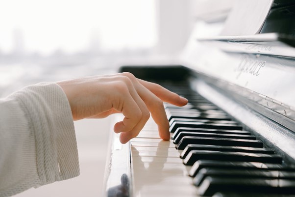 dłoń pianisty grającego na fortepianie